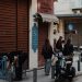 A lively Athens street captures pedestrians, scooters, and shops in the evening light.